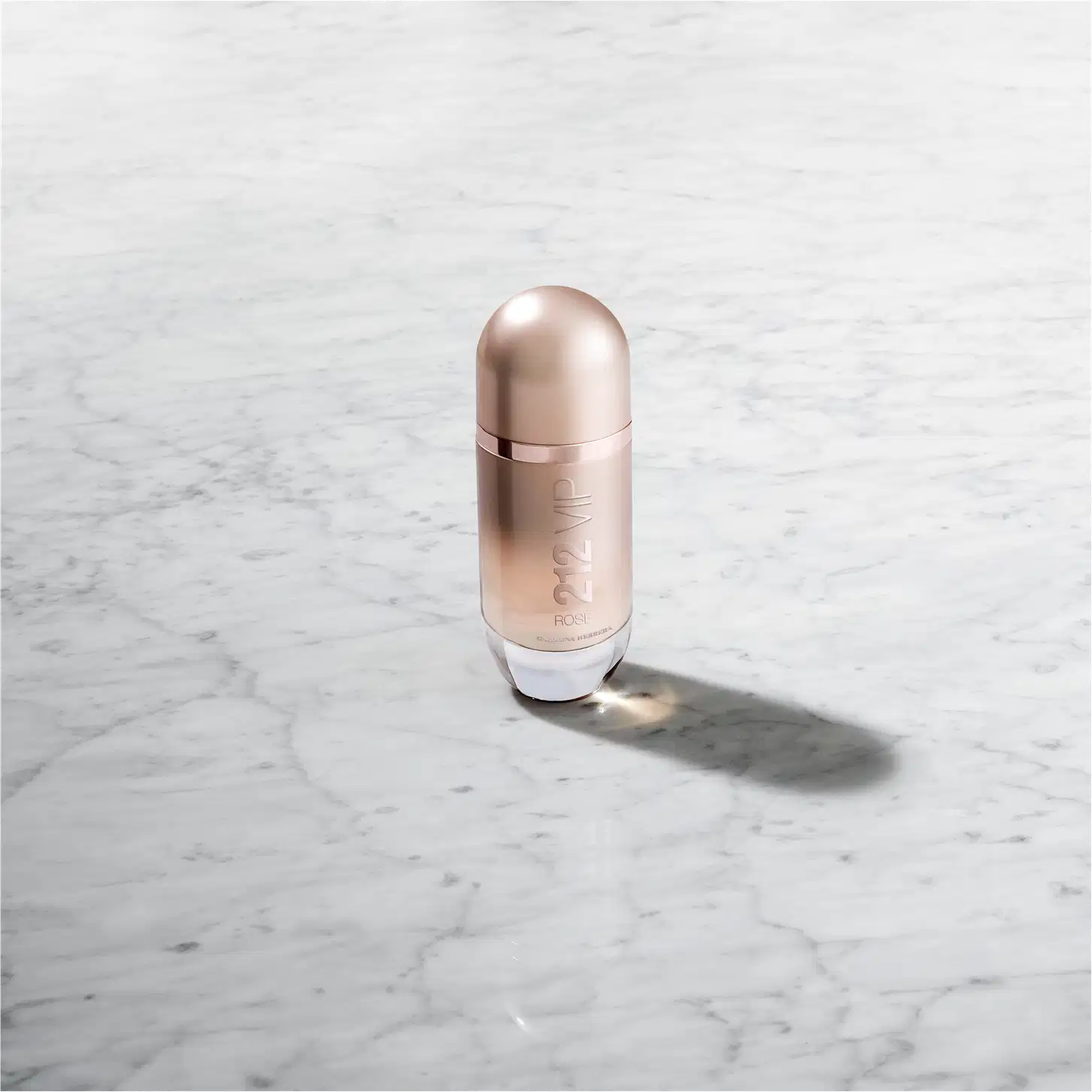 Frasco de perfume Carolina Herrera 212 VIP, com design elegante e minimalista em tons rosados, destacando o nome da marca e a numeração do produto.