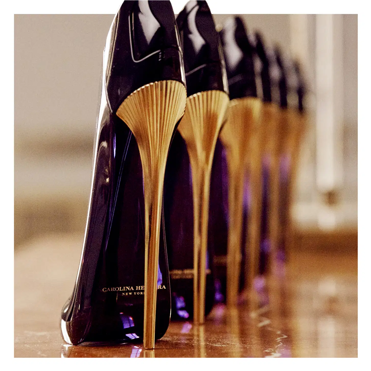 Frasco de perfume Carolina Herrera de design elegante e enigmático, com corpo preto brilhante e detalhes em dourado.