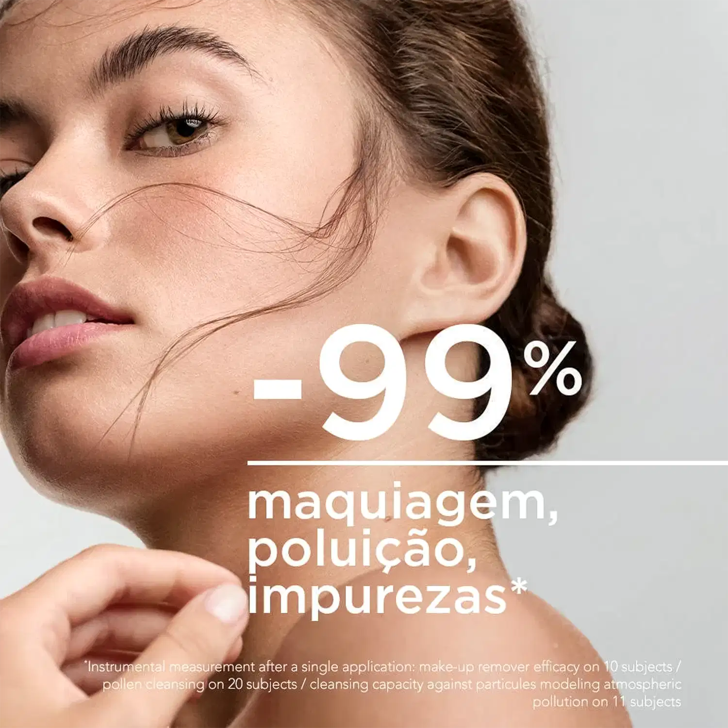 Rosto feminino com cabelos escuros, olhos fechados e texto "-99% maquiagem, poluição, impurezas*" sobre a imagem.