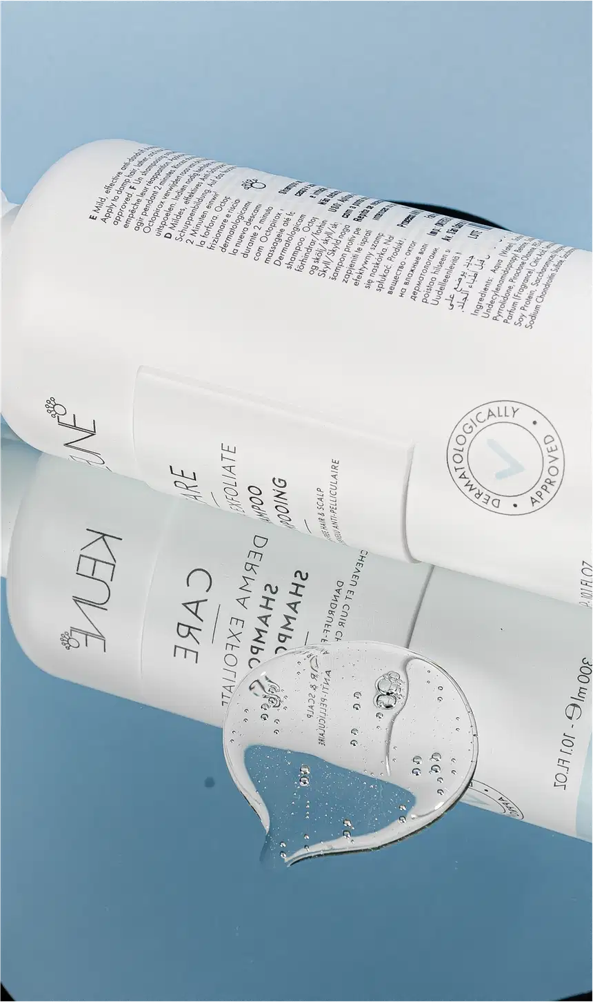 Frasco branco de shampoo Keune Care Derma Exfoliate, com rótulo em preto e branco indicando o nome do produto e sua função de remover caspa do couro cabeludo.