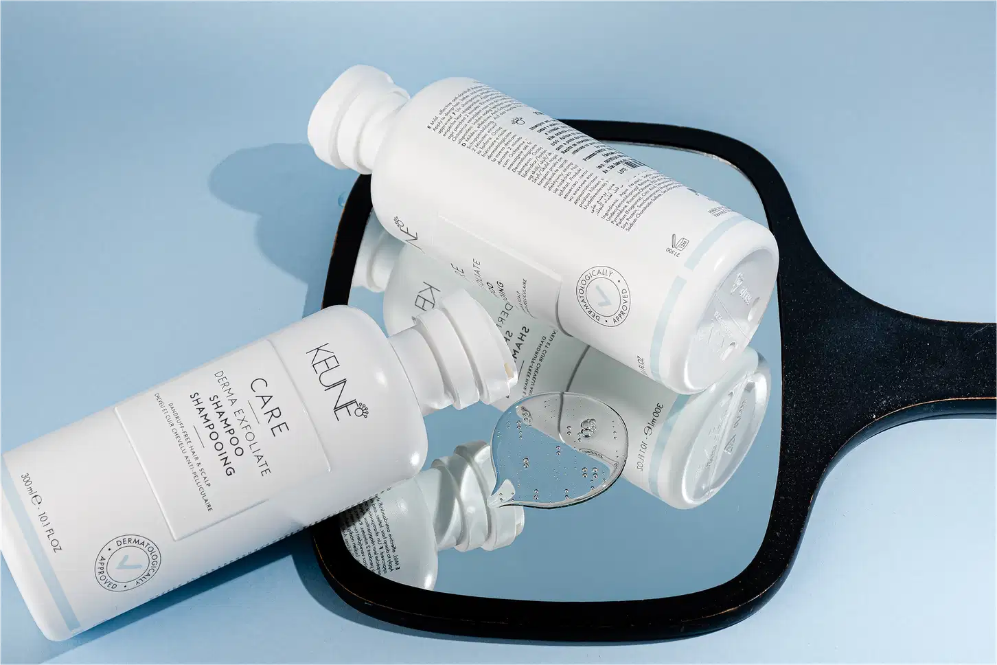 Frasco branco de shampoo Keune Care Derma Exfoliate, com rótulo em preto e branco indicando o nome do produto e sua função de remover caspa do couro cabeludo.