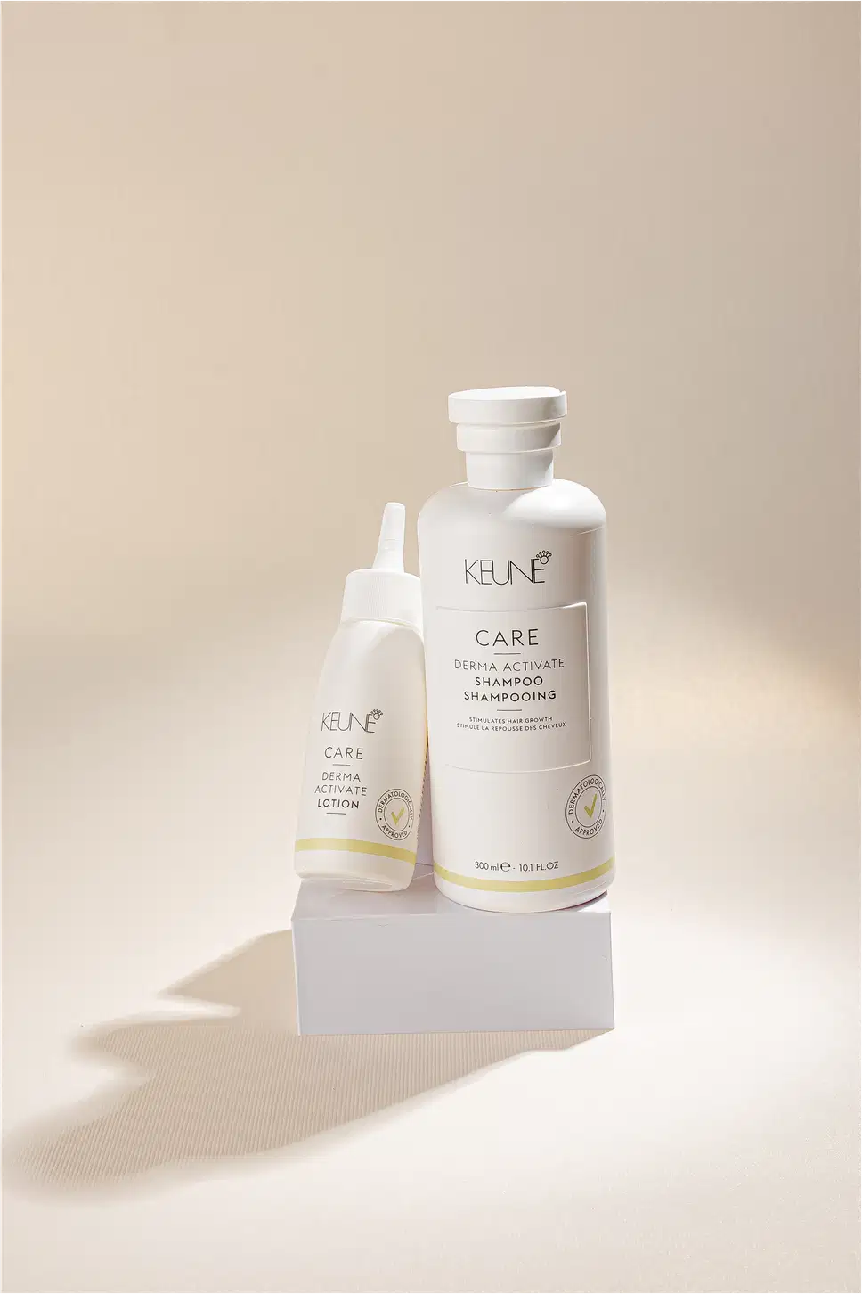 Frasco branco de loção ativadora Keune Care Derma Activate, com rótulo em preto e amarelo, apresentando informações sobre o produto.