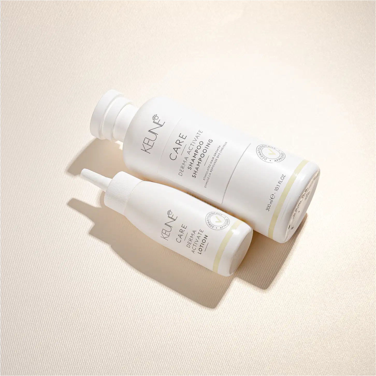 Frasco branco de loção ativadora Keune Care Derma Activate, com rótulo em preto e amarelo, apresentando informações sobre o produto.