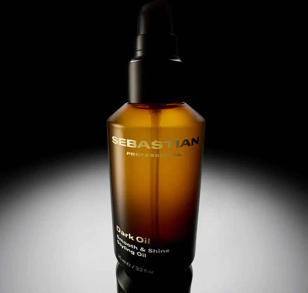 Embalagem de óleo escuro da marca Sebastian Professional, em fundo preto, com destaque para o nome da marca e a descrição "Dark Oil Growth & Shine Styling Oil". 