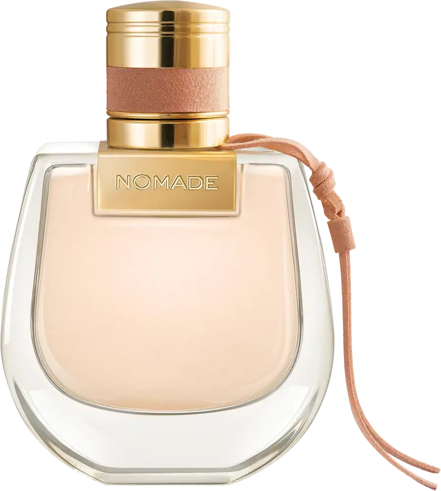 Perfume em frasco de vidro transparente com formato arredondado. A tampa é dourada com detalhes em couro rosé. O nome "NOMADE" está gravado em letras douradas na parte superior da tampa. O líquido dentro do frasco é de uma tonalidade bege claro.