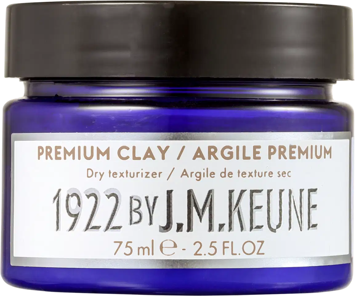 Frasco de cera modeladora da marca Keune, com tampa preta e rótulo branco com texto em dourado. O produto é descrito como um texturizador seco e a embalagem possui 75 ml.