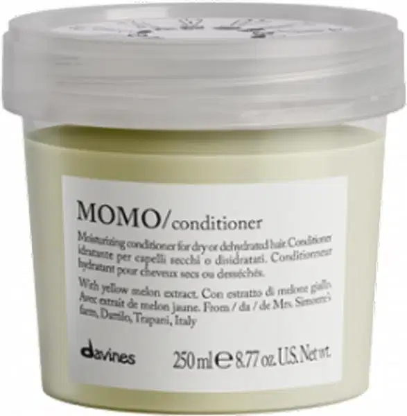 Frasco de condicionador Momo da marca Davines, com tampa transparente e rótulo branco com texto em preto. O produto contém extrato de melão amarelo e é indicado para cabelos secos ou desidratados.