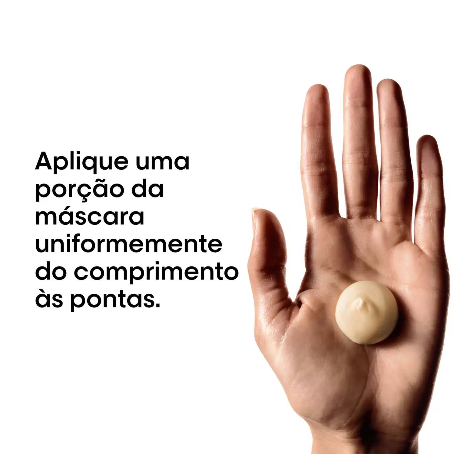 Produto de beleza em embalagem branca com texto em português, aplicado uniformemente sobre os dedos de uma mão, indicando o comprimento ideal da máscara capilar.