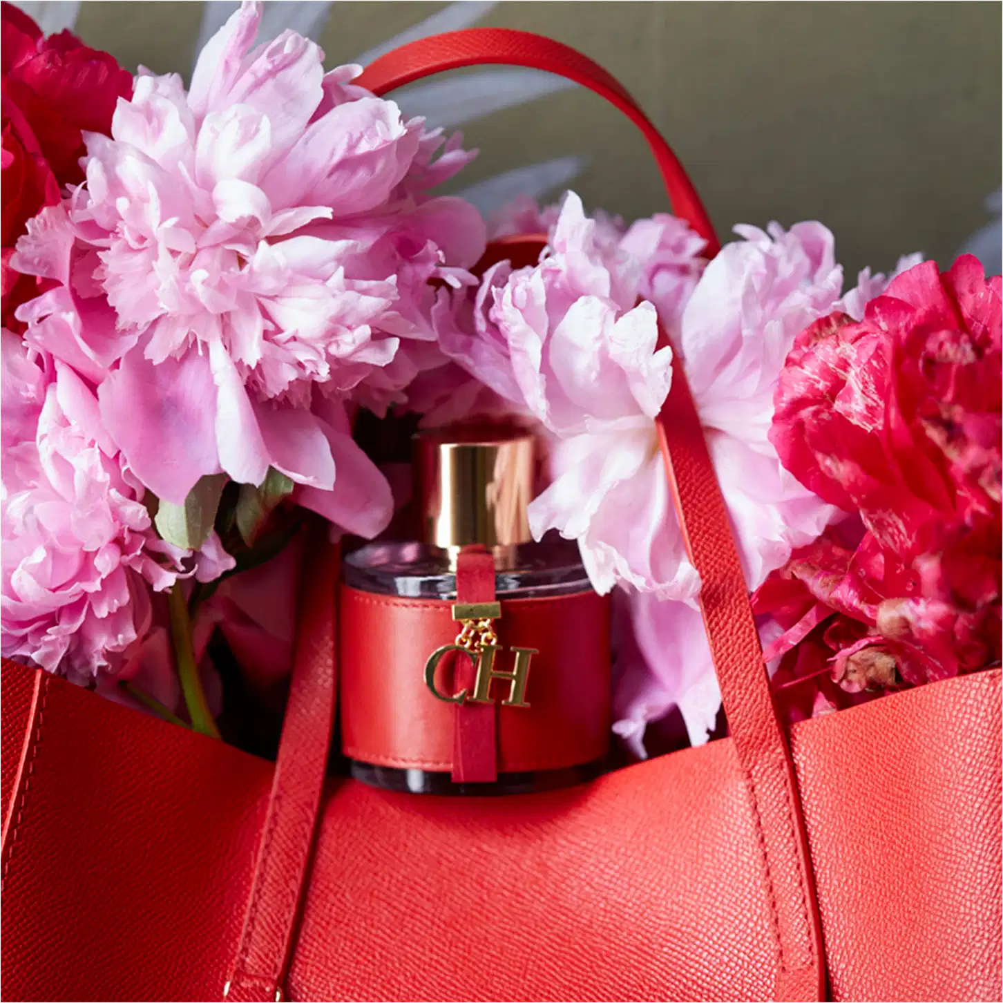 Frasco de perfume Carolina Herrera em embalagem vermelha com detalhes dourados, tampa dourada e logotipo da marca visível.
