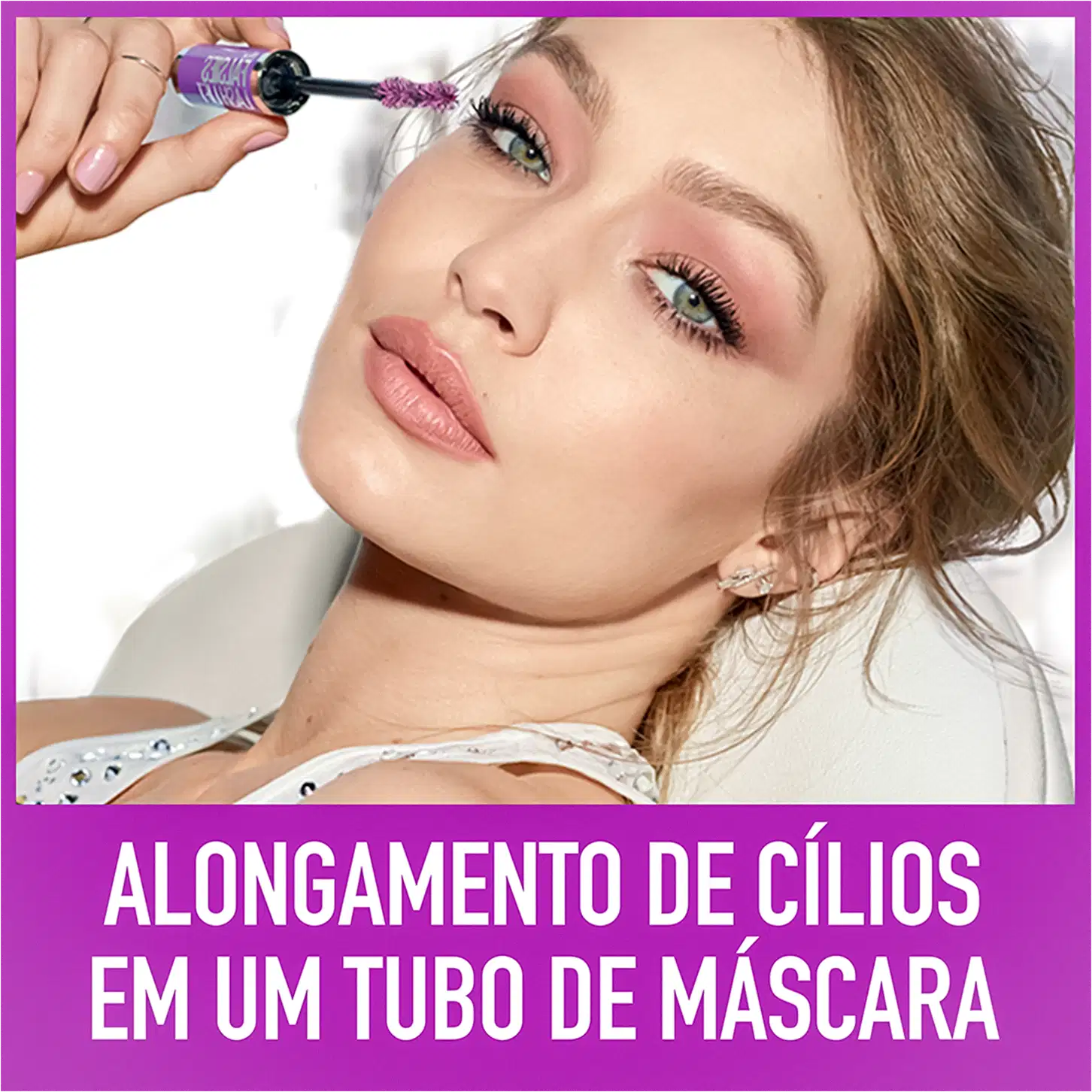 O produto é segurado por uma mão feminina próximo ao rosto de uma mulher jovem, que tem olhos verdes e cílios longos e curvados. O texto na imagem anuncia "Alongamento de cílios em um tubo de máscara".