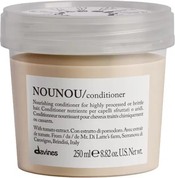 Frasco de condicionador Nounou da marca Davines, com tampa transparente e rótulo branco contendo informações sobre o produto. Embalagem de 250 ml, com extrato de tomate como um dos ingredientes.