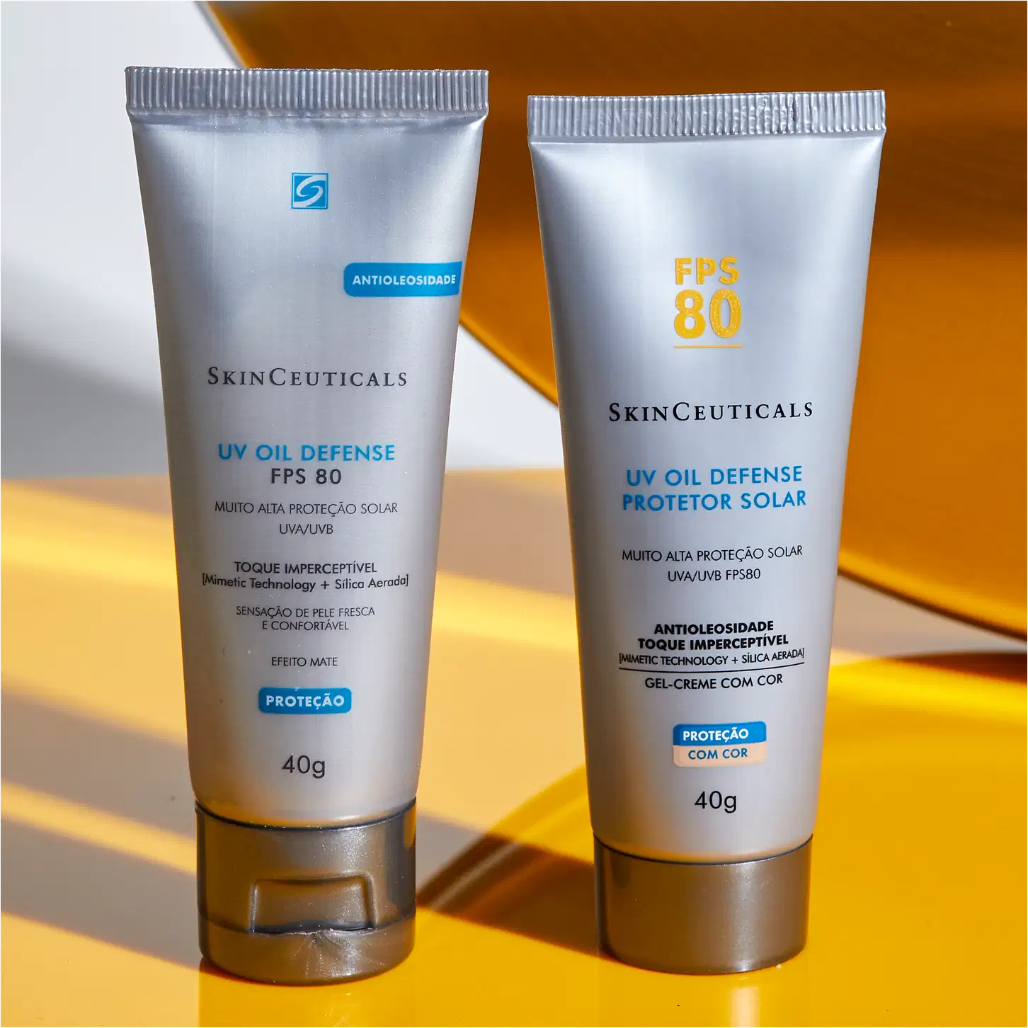 Tubo de protetor solar SkinCeuticals FPS 80 com tecnologia antimanchas, embalagem branca com detalhes em amarelo, informações sobre o produto e sua composição.