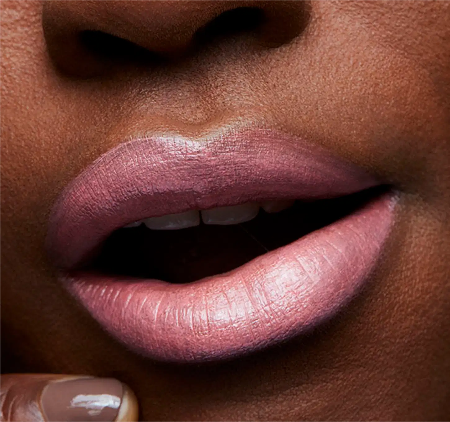A imagem mostra a boca de uma mulher usando o batom.