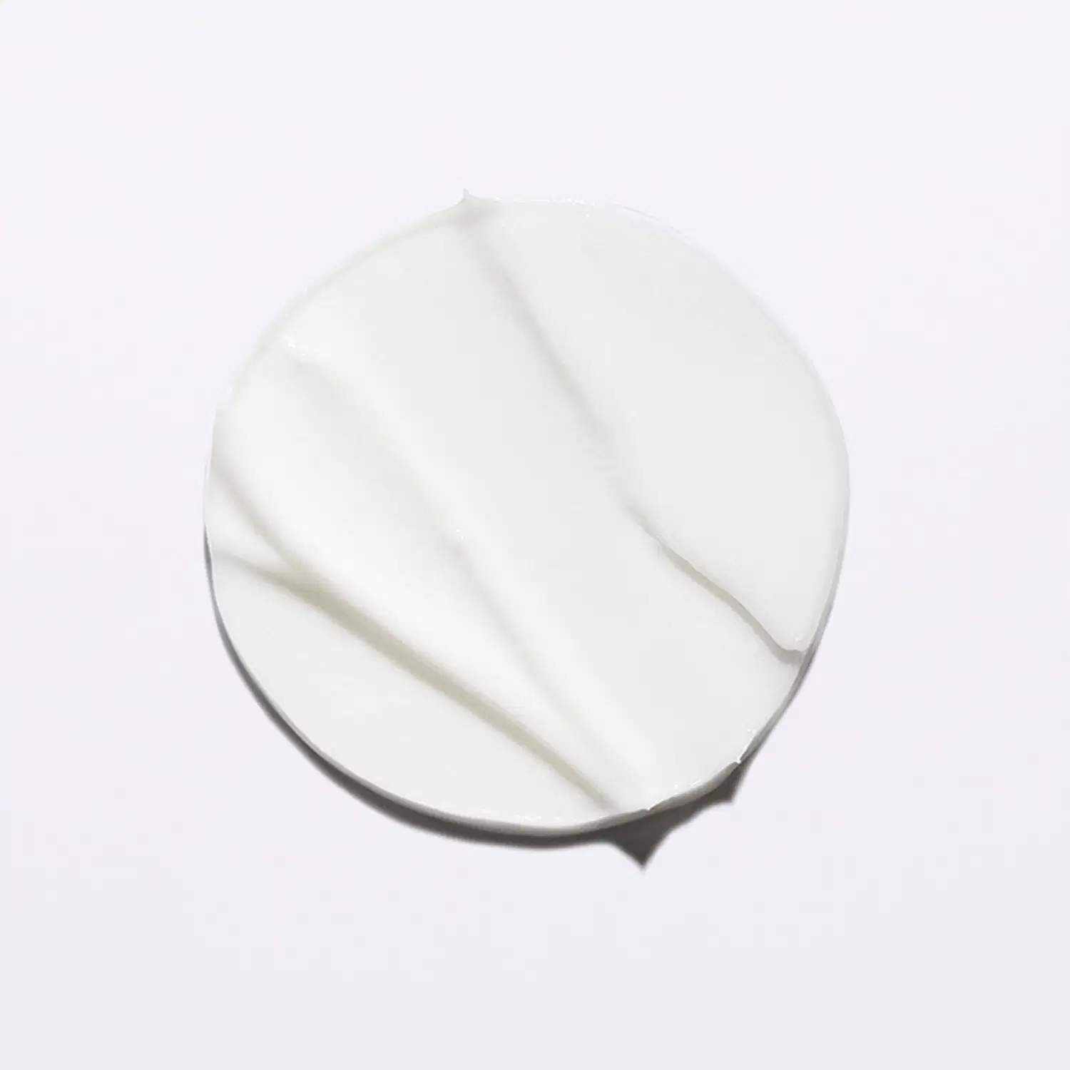 Textura cremosa e sedosa, com aparência suave e brilhante, típica de produtos Kérastase. Sua cor branca e uniforme sugere uma fórmula leve e delicada.