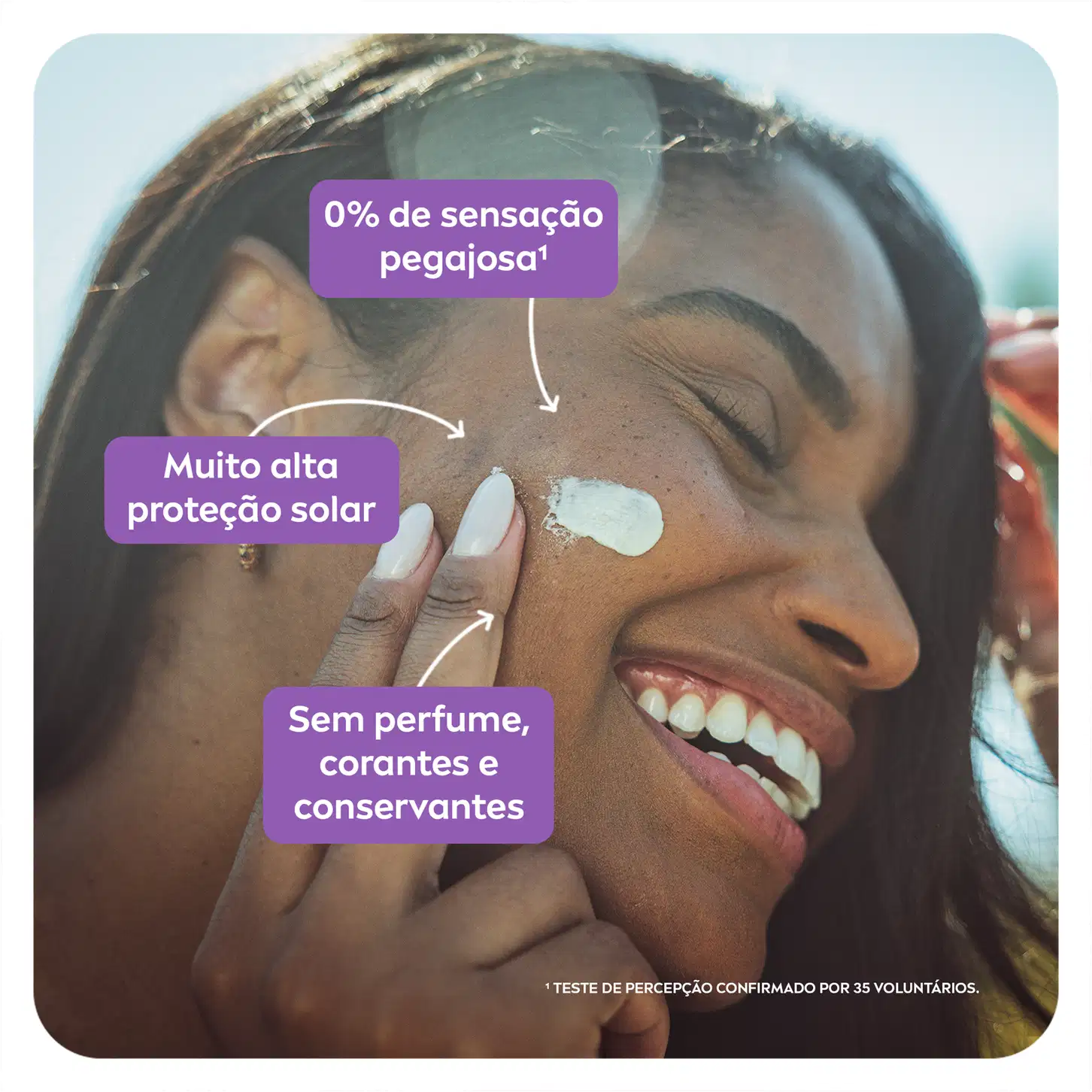 A imagem mostra uma mulher sorridente aplicando o protetor solar no rosto, evidenciando sua textura leve e não oleosa.