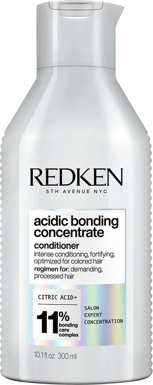 Frasco branco com rótulo da marca Redken. O rótulo apresenta o nome "Acidic Bonding Concentrate" e informações sobre o produto, como "intense conditioning, fortifying, optimized for colored hair". O frasco possui um design cilíndrico com tampa.