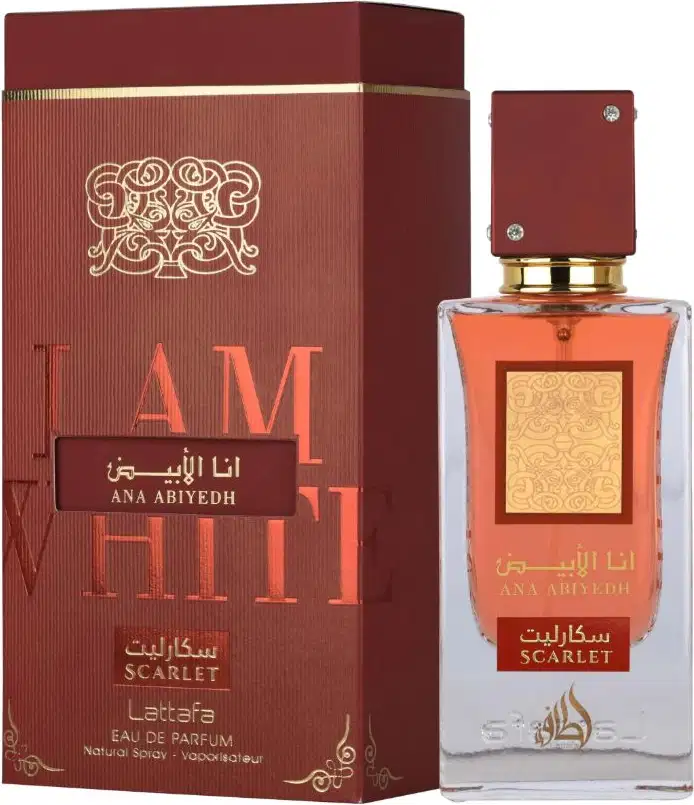 Perfume de luxo da marca Lattafa, em frasco de vidro com tampa dourada, embalado em caixa vermelha com detalhes dourados e texto em árabe e inglês. Produto chamado "Ana Abiyedh" com aroma "Scarlet".