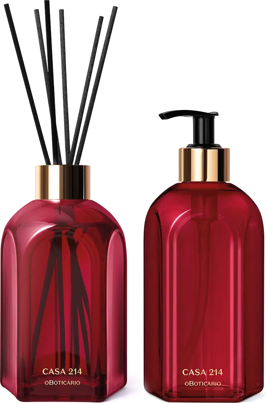 Dois vidros vermelhos da marca Casa 214 Gardênia Imperial: um difusor de ambientes com varetas e o outro com bico dosador preto contendo sabonete líquido.
