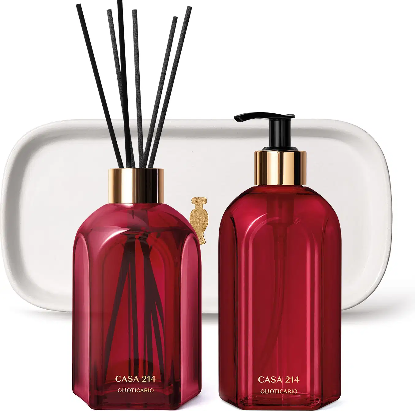 Três produtos da marca Casa 214 Gardênia Imperial: dois vidros vermelhos, sendo um difusor de ambientes com valetas e o outro com bico dosador preto de sabonete líquido e uma badeja de lavabo branca com logo da marca O Boticário em dourado.
