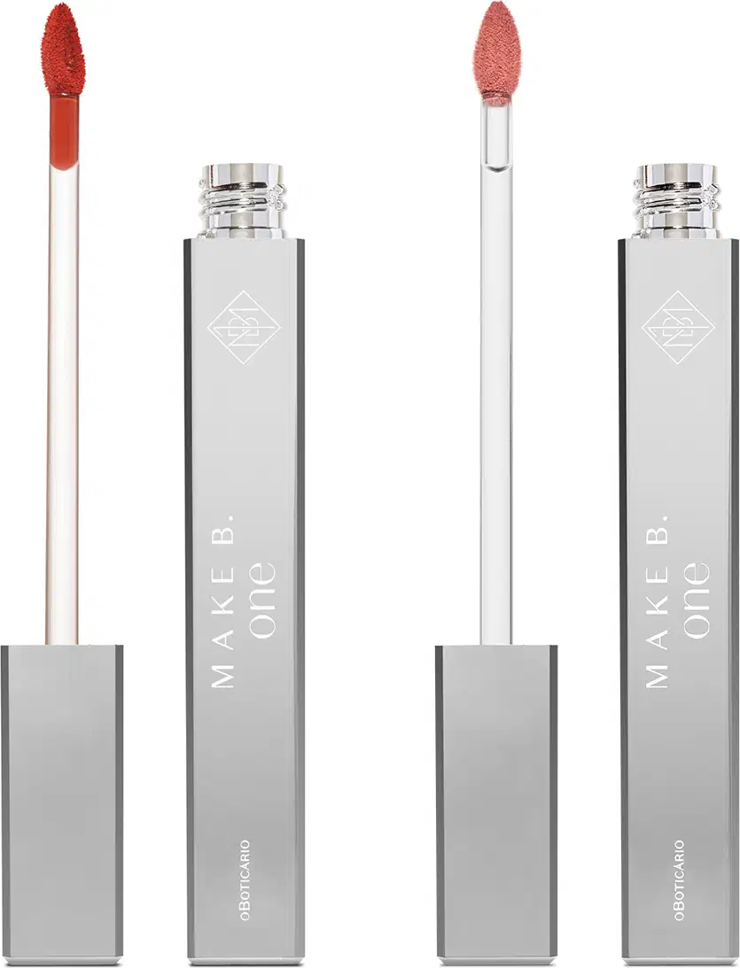 Dois batons líquidos Make B. One Velvet Sublime em tubo prateado com haste branca e esponja aplicadora na cor do produto, sendo um na cor rosa French Rose e outro na cor vermelho Deep Carmine.