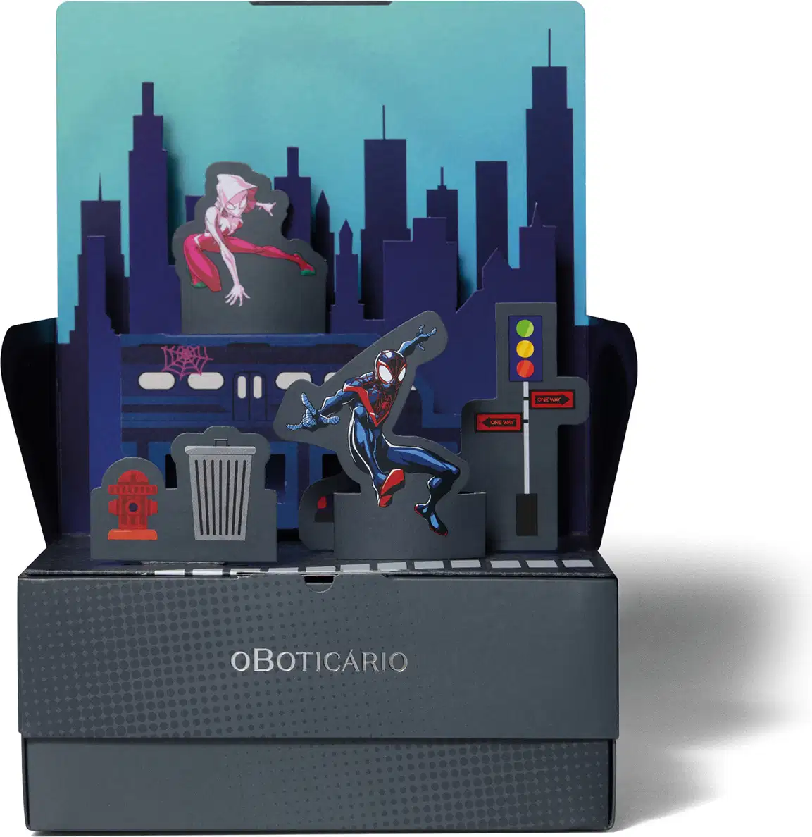 Caixa preta com logotipo oBoticário e sobre ela, um cenário de papel urbano com super-heróis em fundo azul e preto, sugerindo que a caixa se transforma em um cenário de brincadeiras para as crianças.