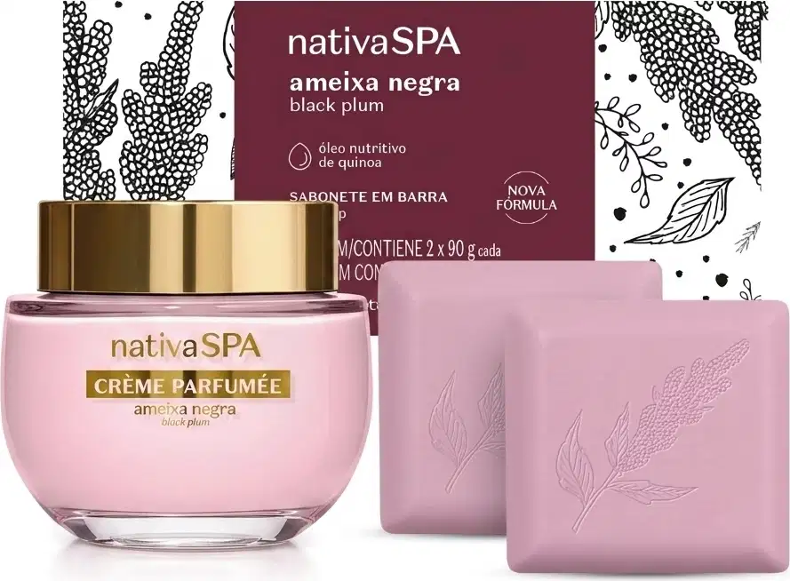 Embalagem de sabonete em barra da linha Nativa SPA Ameixa Negra branca com detalhes ilustrados em preto e rótulo vinho com informações sobre a marca. A frente dela, pote de creme perfumado de vidro com tampa dourada e 2 sabonetes em barra rosa quadrados