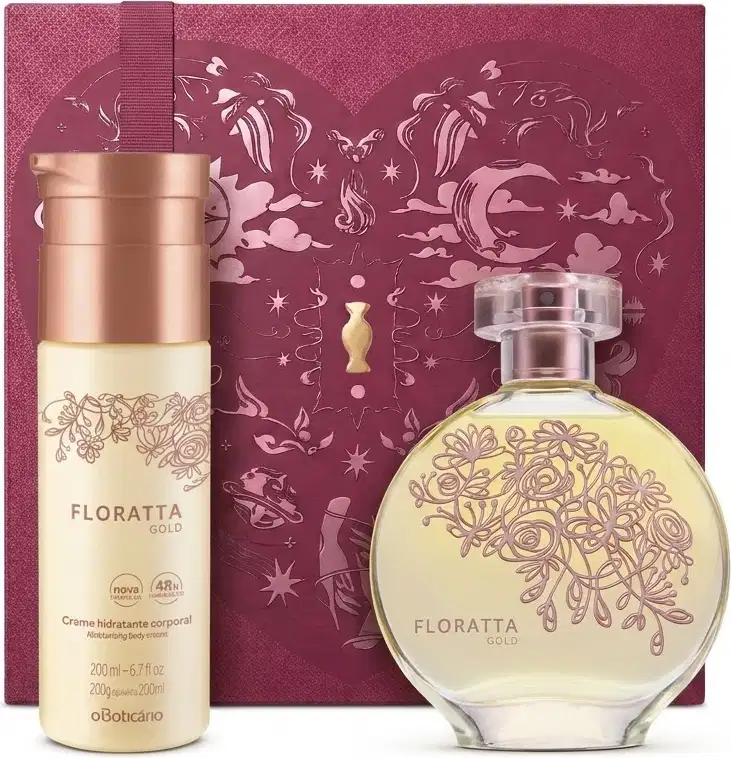 Caixa de presente de cor vinho com um grande coração contendo ilustrações em relevo de temática celestial. Ao lado, um frasco de Floratta Gold em embalagem de frasco de vidro rosa claro e flores em alto relevo e frasco de body spray rosa com tampa rosé.