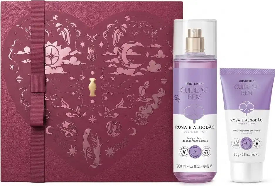 Caixa de presente de cor vinho com um grande coração contendo ilustrações em relevo de temática celestial. Ao lado, uma bisnaga nas cores lilás e branca de antitranspirante, e um frasco de body spray nas lilás e branco da linha Cuide-se Bem Rosa e Algodão