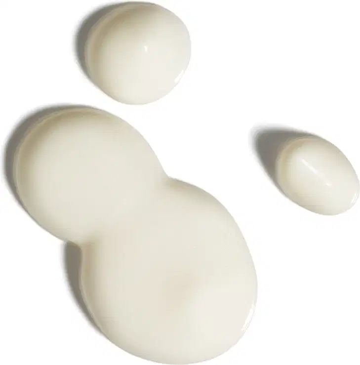 Textura branca e cremosa do protetor solar facial antioxidante FPS 70 Ultra Fluído da marca Boti.Sun, de aparência fluída e brilhante espalhada em superfície branca.