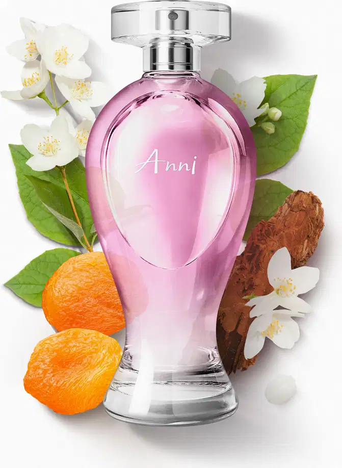 Vidro transparente em formato curvilíneo com líquido rosa, pulverizador prateado e tampa transparente contendo desodorante colônia Boticollection Anni cercado por flores brancas, folhas verdes, madeira e damascos.