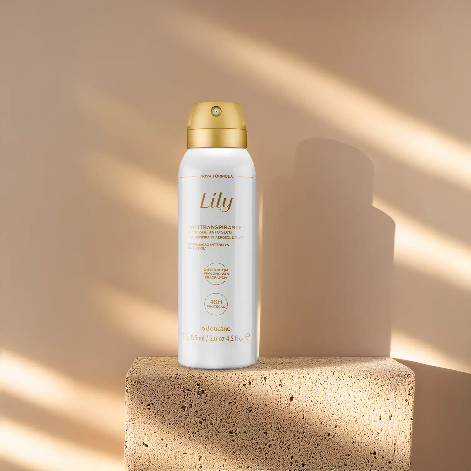 Um frasco branco com tampa e letras douradas de desodorante antitranspirante aerossol da marca Lily está em cima de uma pedra simulando mármore e em fundo rosa com muitas sombras.