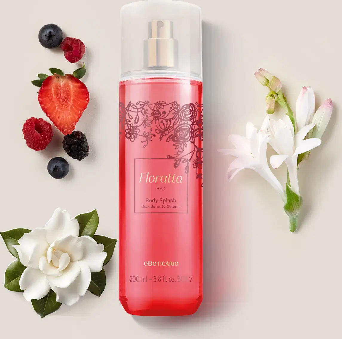 Frasco rosa com detalhes em vinho e letras douradas, pulverizador prateado e tampa cristal de body splash Floratta Red. cercado por frutas vermelhas, flores brancas e folhagens sobre fundo bege claro.