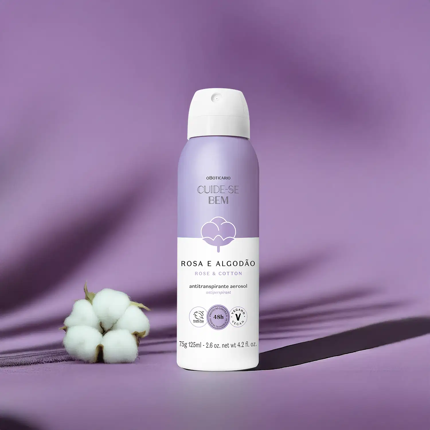 Frasco lilás e branco de desodorante antitranspirante aerossol da marca Cuide-se bem Rosa e Algodão sobre fundo roxo com sombras suaves.