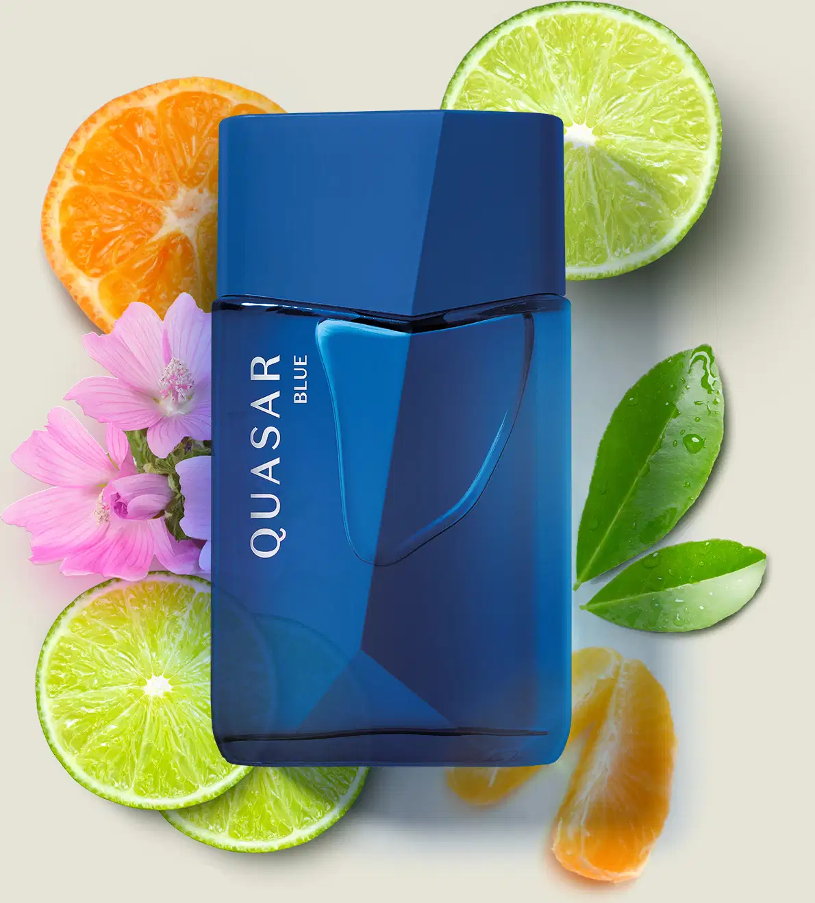 Frasco de vidro em formato geométrico com letras amarelas contendo desodorante colônia Quasar Blue sobre superfície clara, rodeado por fatias de frutas cítricas, folhas verdes e flores rosa.