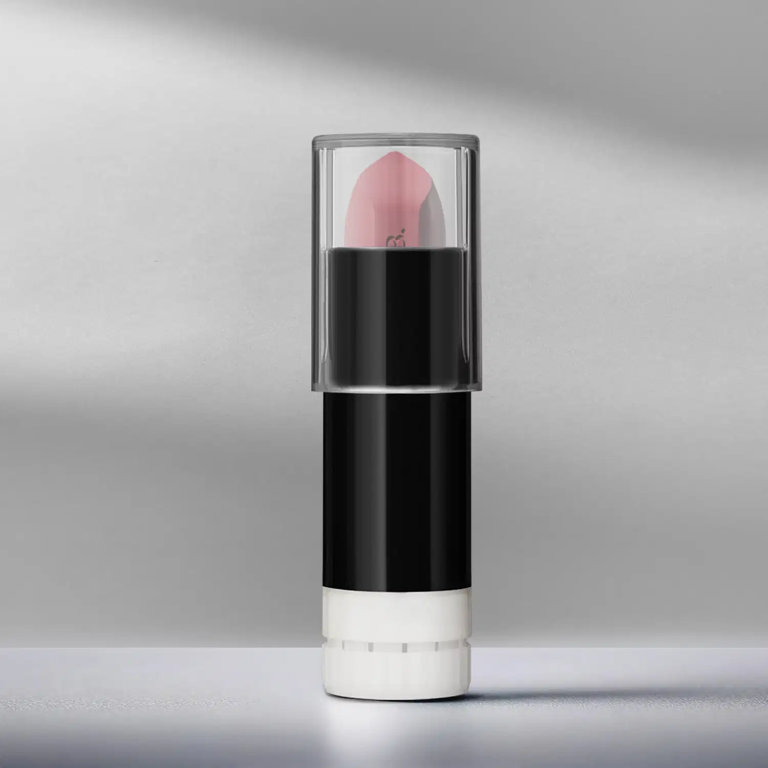 Refil de batom mate rosa Rose Fabulous Make B. em embalagem preta e branca com tampa transparente, posicionado em superfície cinza clara com fundo desfocado em tons de cinza.