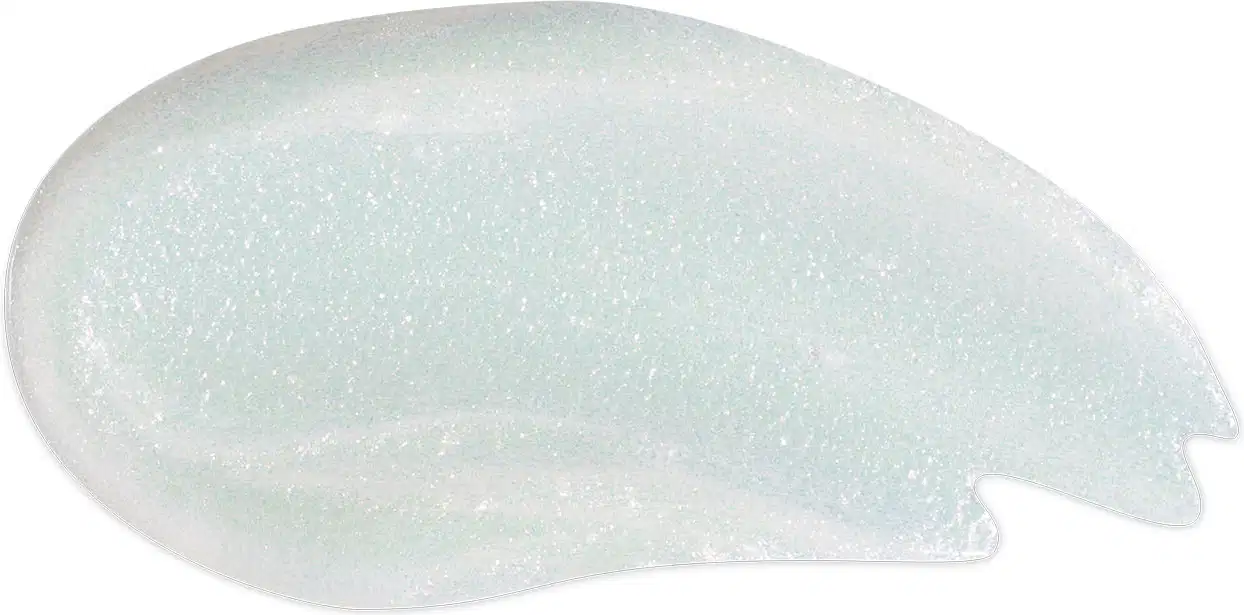 Textura molhada, brilhante e branca do gloss labial incolor Glossy Plastic Lips da marca Intense Melissa. Ele tem aparência fluída e está espalhado em superfície lisa e branca.