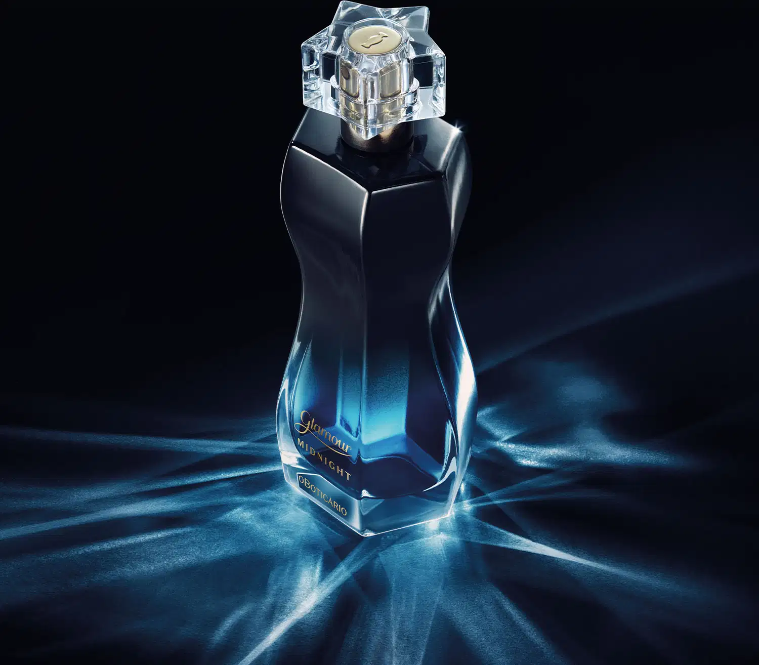 Vidro curvilíneo com degradê de preto e azul, borrifador dourado e tampa transparente de desodorante colônia Glamour Midnight em fundo escuro com reflexos e iluminação dramática, sugerindo um ambiente elegante e sofisticado.