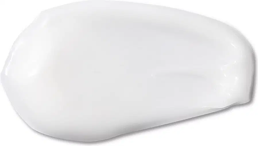 Textura branca e cremosa de condicionador suave da marca Boti Baby com aparência fluída e brilhante, espalhada em superfície branca.