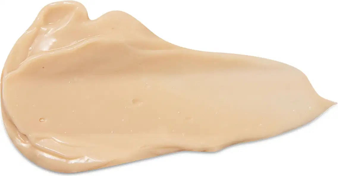 Textura cremosa e amarela da loção radiante corporal Nativa SPA Ameixa Dourada com aparência brilhante e lisa, espalhada em superfície branca.