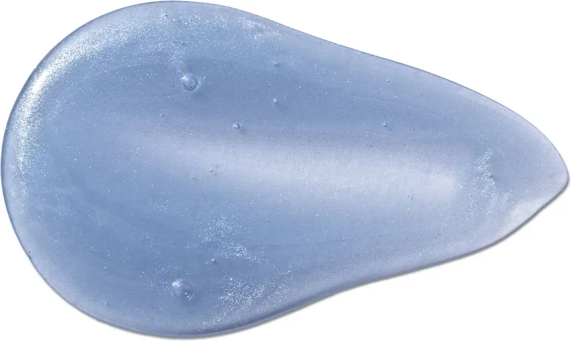Imagem da textura brilhante e translucida do shampoo infantil para cabelos lisos Dr. Botica, de cor azul e aspecto gelatinoso em superfície lisa.