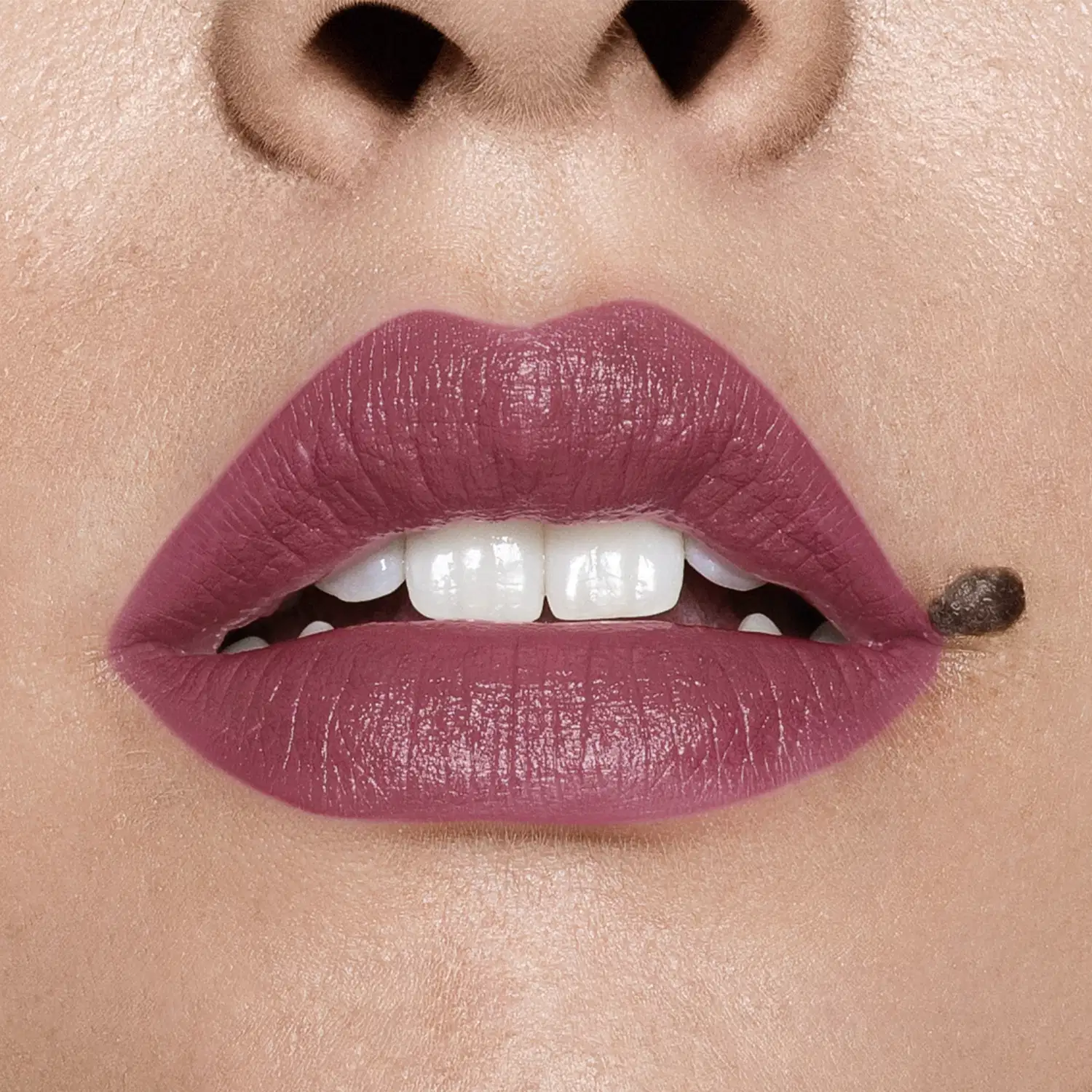 Close-up de um rosto feminino evidenciando os dentes brancos e os lábios em tom de rosa intenso que usa o batom cremoso na cor rosa 250 da marca Intense