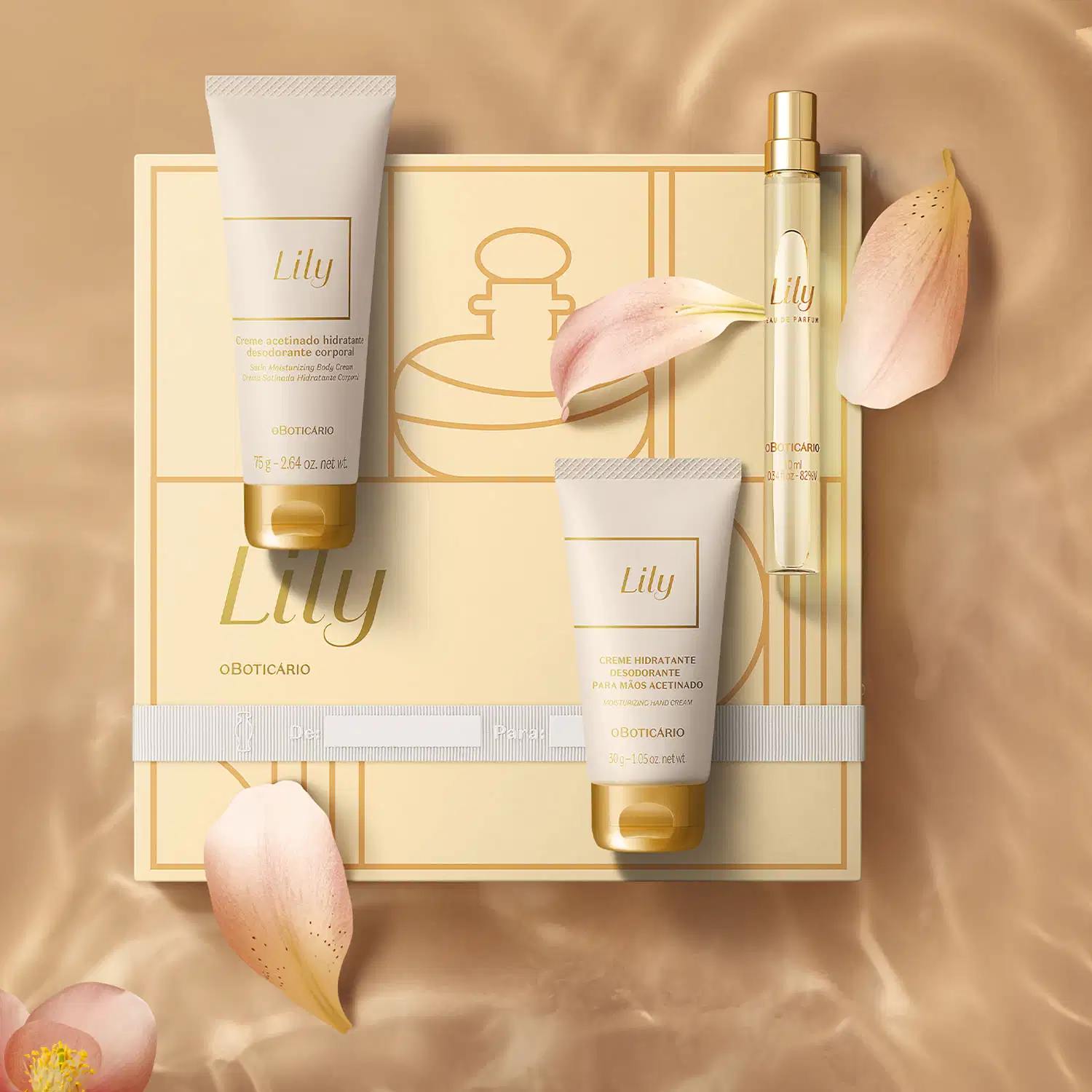 Quatro itens Lily em tons de branco, bege e dourado: caixa de presente com ilustrações e fitas, frasco de creme hidratante corporal, bisnaga de creme hidratante para as mãos e tubo de 10ml de Eau de Parfum, sobre superfície bege com pétalas de flor rosa.