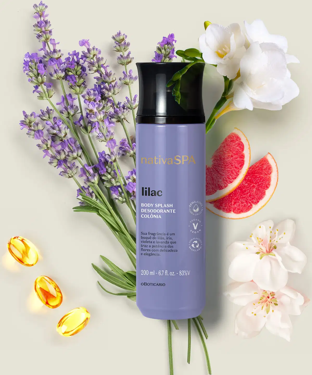 Buquê de lavanda, flores brancas e fatias de toranja em superfície clara, com um frasco cilíndrico na cor lilás com tampa preta e letras brancas e pretas  de body splash Nativa SPA Lilac.