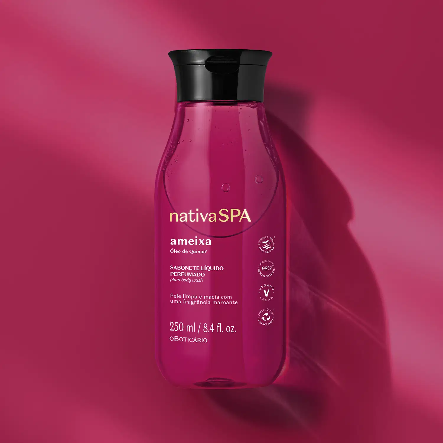Frasco na cor rosa vibrante com tampa preta e rótulo com letras douradas e brancas contendo sabonete líquido perfumado Nativa SPA Ameixa em fundo em tons de rosa.
