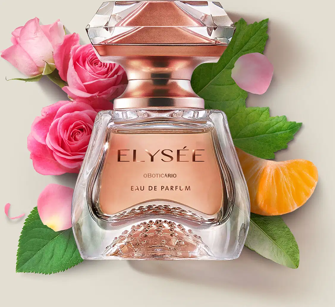 Frasco de Eau de Parfum Elysée sobre superfície clara, rodeado por rosas cor de rosa, folhas verdes e uma fatia de laranja, em cenário minimalista e claro.