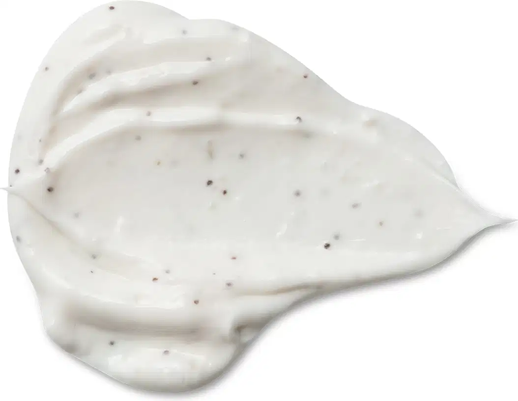 Textura cremosa e brilhante do creme esfoliante corporal Cuide-se Bem Feira Coco com pequenos pontos escuros dispersos, em fundo branco.
