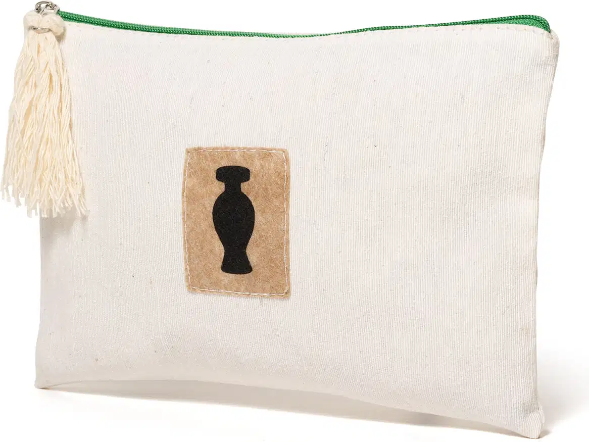Nécessaire retangular de tecido bege com zíper, pingente e detalhe marrom com o logo da marca O Boticário em preto na frente do produto.