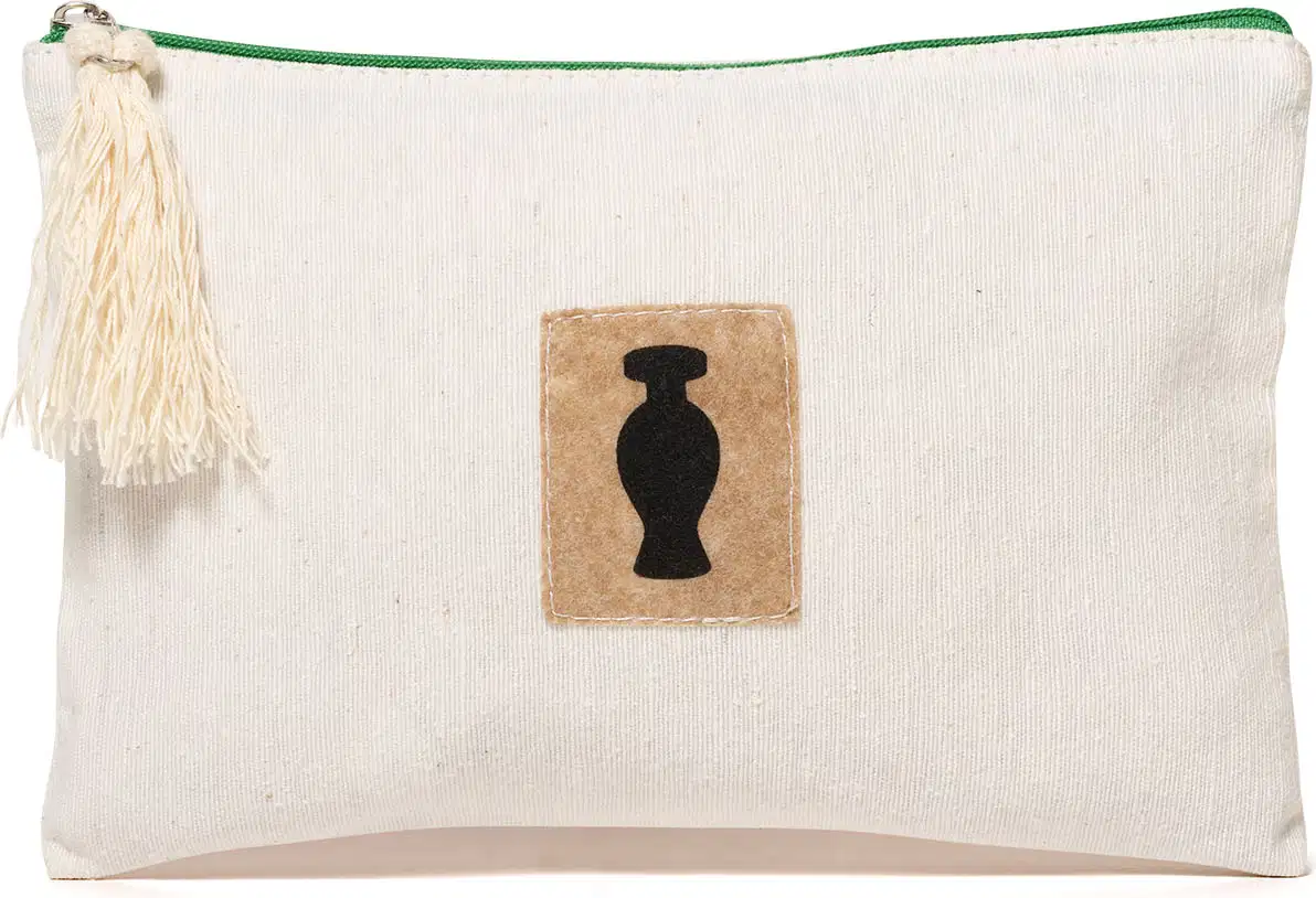 Nécessaire retangular de tecido bege com zíper, pingente e detalhe marrom com o logo da marca O Boticário em preto na frente do produto.