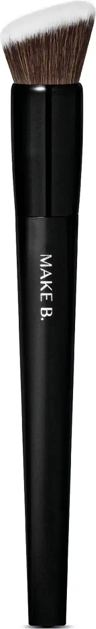É um pincel de maquiagem de formato cilíndrico e alongado. O cabo é preto e possui o texto "MAKE B." impresso. As cerdas são macias e de cor castanha escura.  O design é simples e minimalista, com o foco no desempenho e funcionalidade do produto.