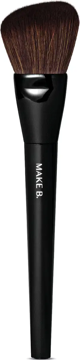 É um pincel de maquiagem de formato cilíndrico e alongado. O cabo é preto e possui o texto "MAKE B." impresso. As cerdas são macias e de cor castanha escura.  O design é simples e minimalista, com o foco no desempenho e funcionalidade do produto.